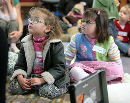 Amelia and Claudia wait for story time to begin on the mat at the Feelix library