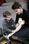 Sigrid Thornton holding one of the tactile objects from a Feelix kit as a young boy touches it