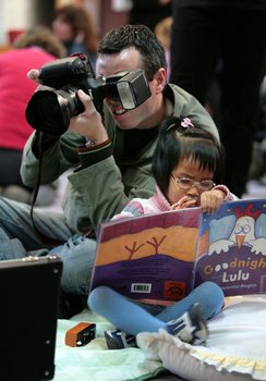 A photographer taking a shot whilst Anna reads Operation Lulu