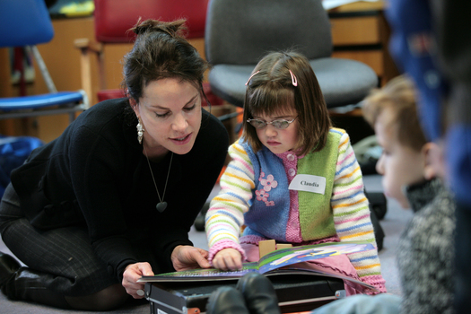 Sigrid Thornton reading a book with Claudia in the Feelix library