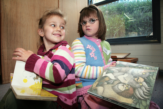 Kate with 'Rosie's Walk' and Claudia holding 'Where the Wild Things Are' in the Feelix library