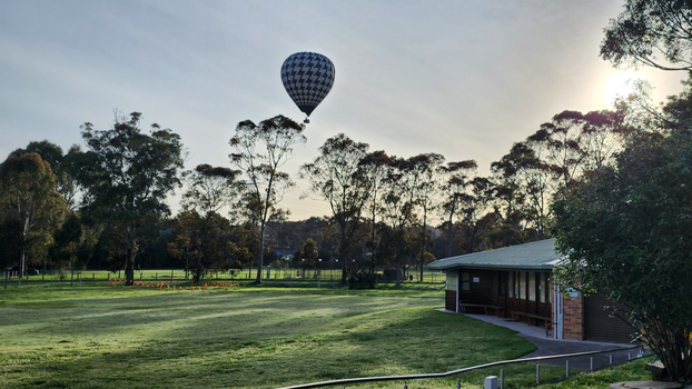Hot air balloon descending to Malvern sport ground, view from near Blind Cricket pavilion