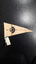 Cream felt flag with words 'Association for the Blind' in caramel, standing on black base