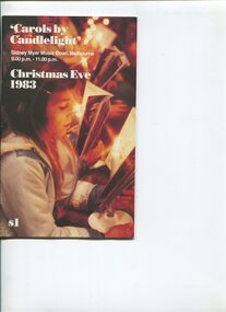 Side view of girl holding candle as she reads carols program