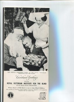 Schoolboy sits on Santa's knee whilst a nurse touches him on the shoulder and holds a present above the pair