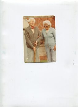 Male holds wooden stick whilst female smiles and looks on