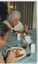 Older woman eating a plate of vegetables and meat in stew