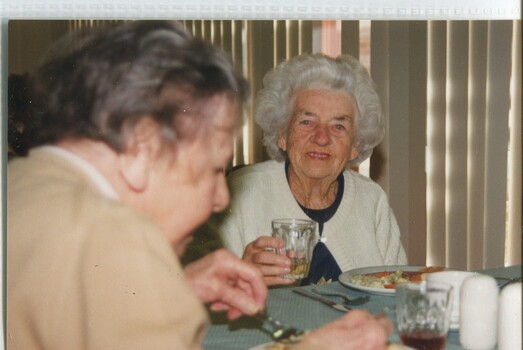 Woman looks to camera as she lifts her glass