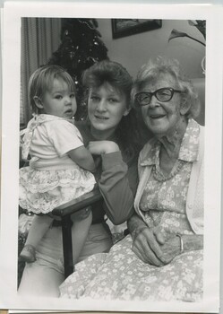 Elderly woman sits with her great grand daughter and her daughter