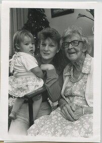 Elderly woman sits with her great grand daughter and her daughter