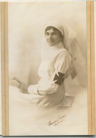 Seated woman dressed in nursing uniform with armband