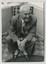 Man seated on chair wearing suit with AFB lapel pin