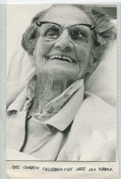 Elderly woman sitting in bed smiling for the camera