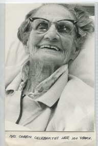 Elderly woman sitting in bed smiling for the camera