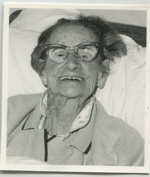 Elderly woman sitting in bed smiling for the camera