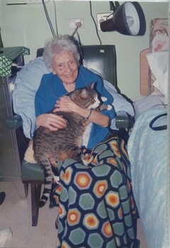 Older woman with large tom cat sitting on her lap