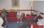 Four residents sit on red lounges, two clapping their hands