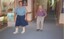 A nurse walks along the hallways with a resident following