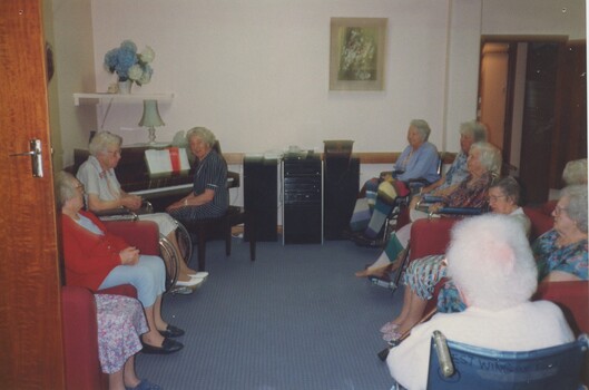 Group of residents during a sing a long with pianist and piano