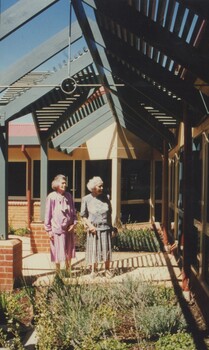 Two female residents looking at the building from the garden