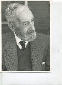 Whiskered man with combed down hair, jacket, vest, shirt and tie