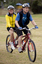 Man in yellow bicycling outfit riding on a tandem bike