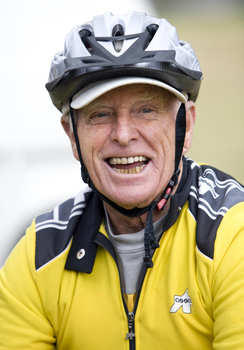 Man in yellow biking helmet smiling towards camera