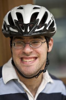 Younger man wearing bicycle helmet and smiling for camera