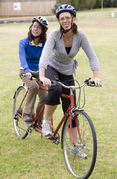 Two women about to take off on a tandem cycle