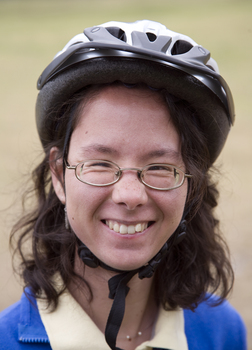 Woman wearing bicycle helmet smiling for camera