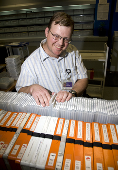 Tim Mitchell with a trolley of returned cassettes and Daisy books