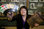 Michele Prentice holding a card holder with Braille UNO cards and a base board for a braille frame