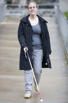 Penny Stevenson walking from Talbot Rd using a white cane