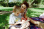 Sigrid and various children sit on a picnic blanket in a grassed area