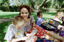 Sigrid and various children sit on a picnic blanket in a grassed area