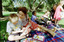 Sigrid and various children sit on a picnic blanket in a grassed area