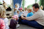 Families in front of a rotunda watching Sigrid Thornton read 'Owl Babies'