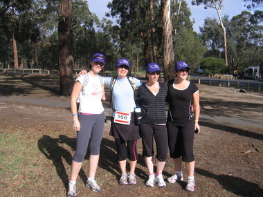 Four women dressed in walking gear near a trail
