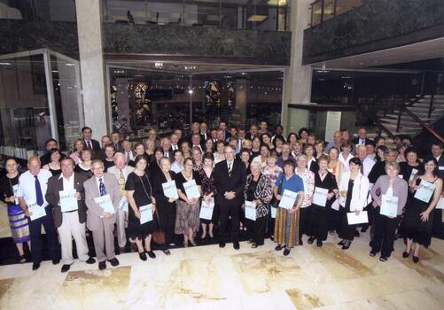 Large group of people in foyer of National Library holding awards