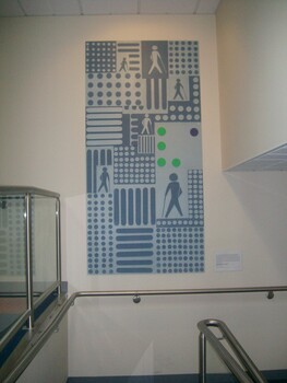 Dots and lines with white cane image and VA in Braille on lower walkway