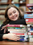 Renee leaning on a pile of books in the browsing library