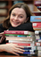 Renee leaning on a pile of books in the browsing library