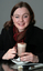 Renee sitting in the Kooyong cafe with a hot chocolate and white cane on the table