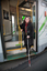 Renee disembarking from a tram with her white cane