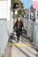 Renee crossing the train tracks at Kooyong station using her white cane