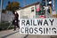 Renee crossing the train tracks at Kooyong station using her white cane