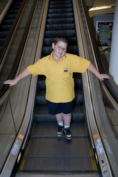 Richard Carbone stands on descending escalator
