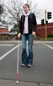 Anna crossing the road with her cane