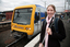 Anna waiting on the platform with a train behind her