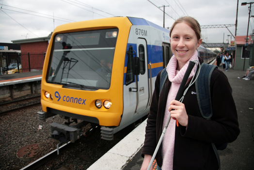 Anna waiting on the platform with a train behind her
